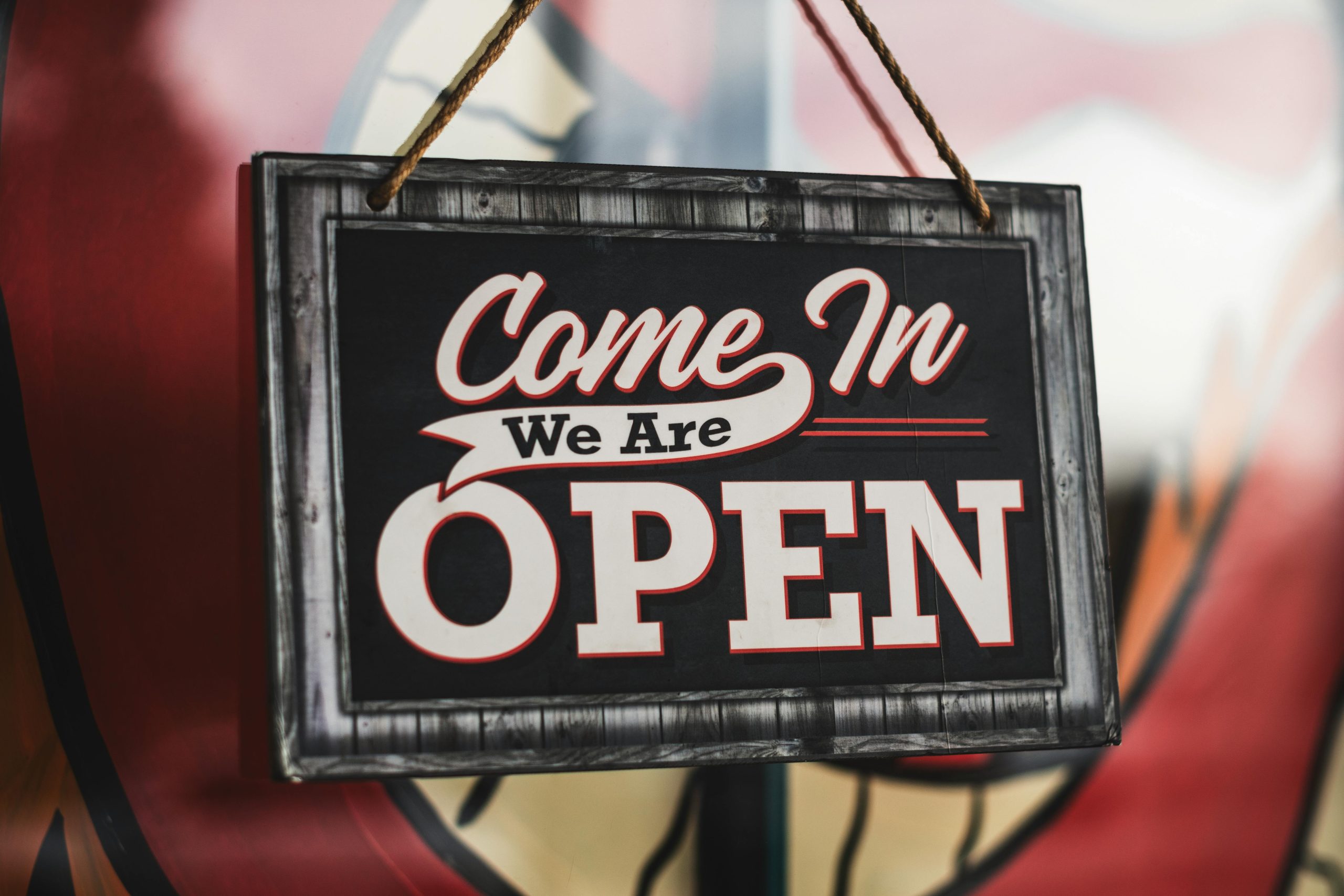 Schwarzes Firmenschild mit Aufschrift Come In We Are Open