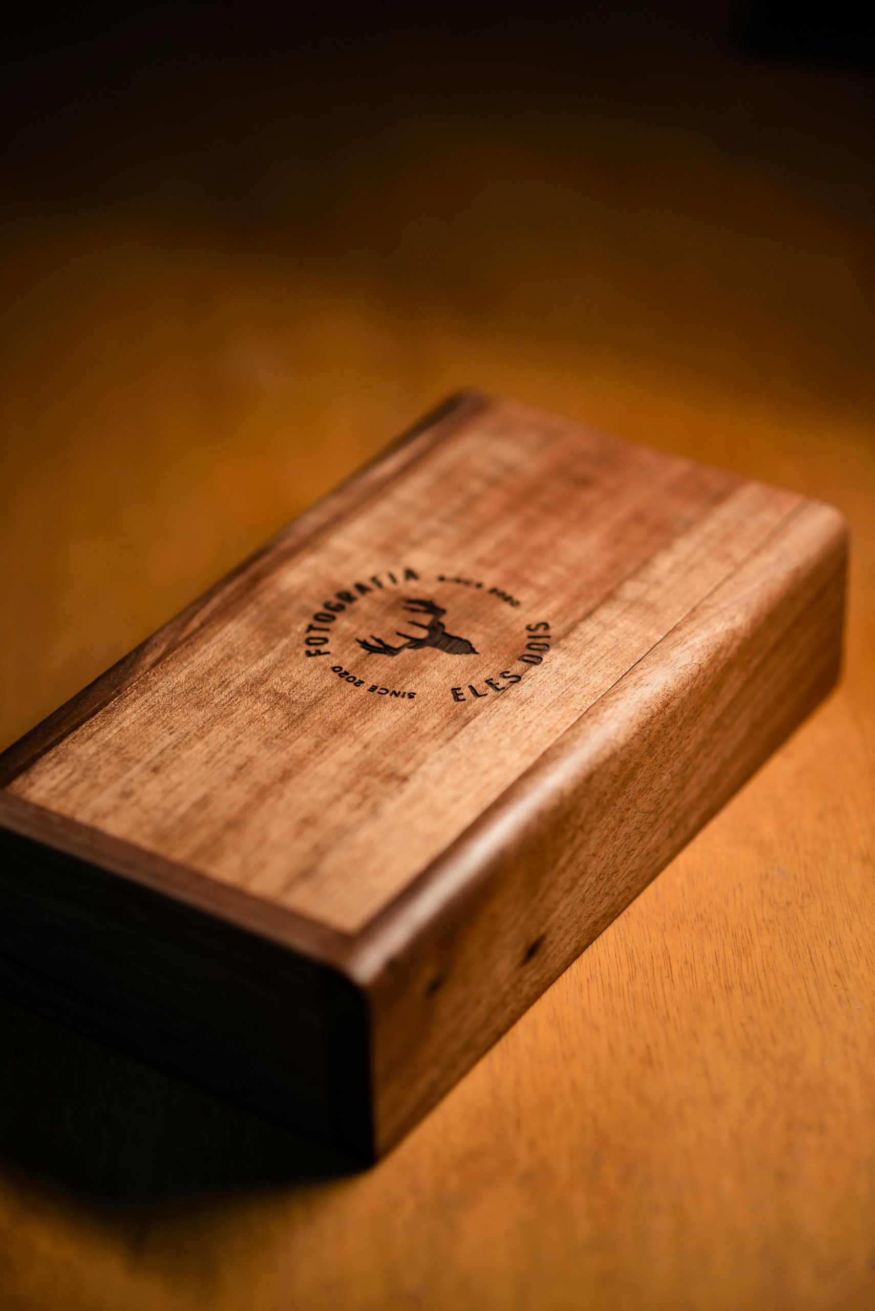 Holzbox mit lasergraviertem Logo auf warmem Holzuntergrund