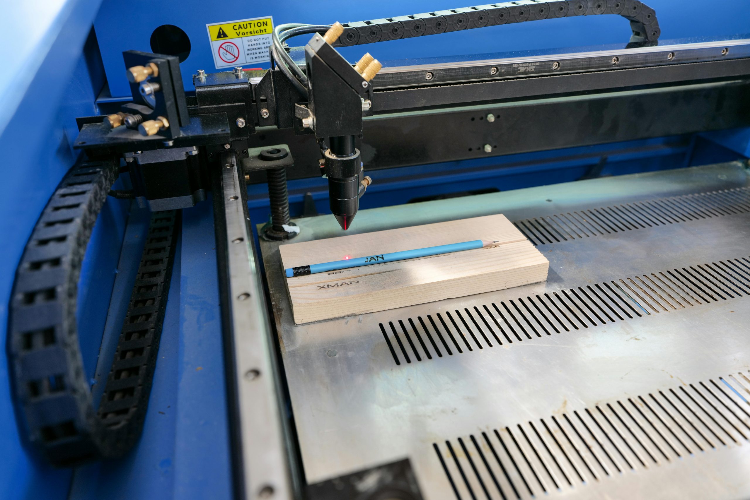 Lasergravurmaschine graviert Text auf einen Holzblock